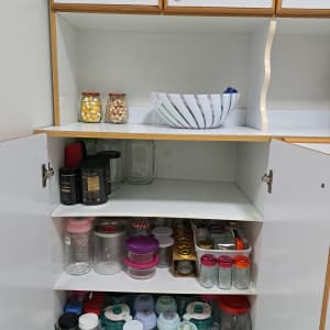 ארון מטבח מאורגן עם צנצנות ומיכלים שונים