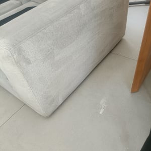 ספה אפורה על רצפה נקייה עם שואב אבק