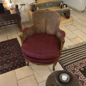 כורסת עץ עתיקה עם גב קש וריפוד בד בגוון ארגמן
