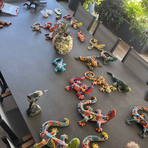 שולחן עם כלי עבודה ופסלים צבעוניים של לטאות