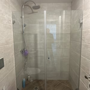 מקלחת עם דלת זכוכית וראש מקלחת