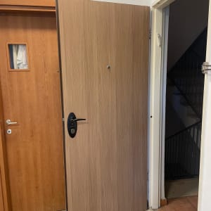 דלת עץ פתוחה עם ידית שחורה ומנעול