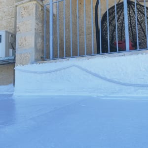 איטום גג עם חומר לבן ליד מעקה מתכת