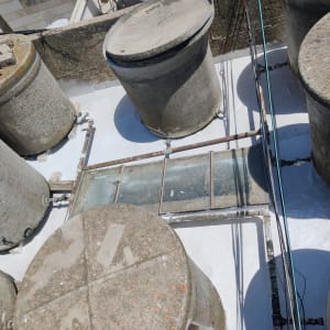 מיכלים עגולים על גג עם צינורות ואיטום לבן