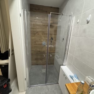 מקלחון זכוכית עם קירות עץ וראש מקלחת