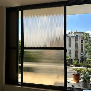 חלון זכוכית עם צמחים על אדן החלון