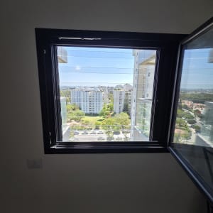 חלון אלומיניום פתוח עם נוף לעיר