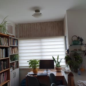 חלון עם וילון לבן בחדר עבודה מואר