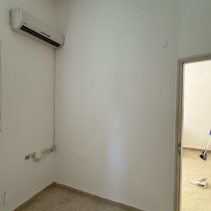 קיר צבוע בלבן עם מזגן תלוי