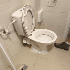 אסלה עם מכסה פתוח וצינור חיבור