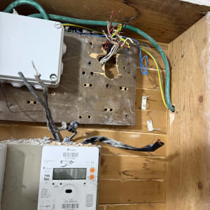 תמונה של לוח חשמל עם חוטים חשופים ומונה חשמל