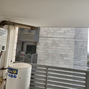 התקנת רשת שקופה נגד יונים במרפסת שירות ומסתור כביסה