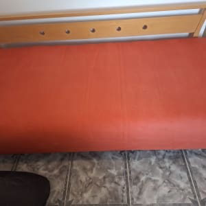 ספה עם כיסוי כתום על רצפת אריחים