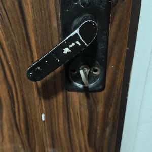 ידית דלת מתכתית על דלת עץ