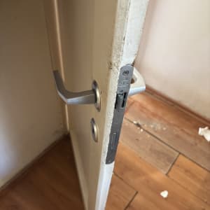 דלת עם מנעול וידית מתכת על רצפת עץ