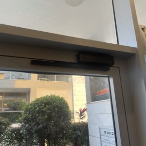 דלת זכוכית עם מנגנון סגירה אוטומטי עליון