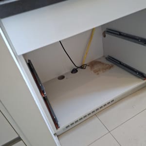 ארון מטבח פתוח עם חוטי חשמל ותושבות מגירות