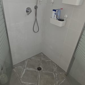 מקלחת עם ראש מקלחת ומדפים