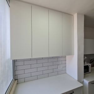 ארונות מטבח לבנים עם משטח עבודה וכיריים