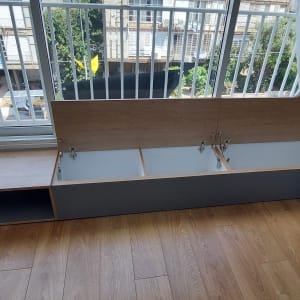 ארון עץ עם דלתות פתוחות ליד חלון גדול