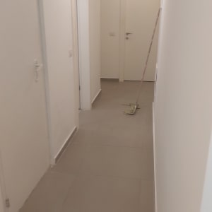 מסדרון דירה ריקה לאחר צביעת קירות בלבן עם רולר צבע