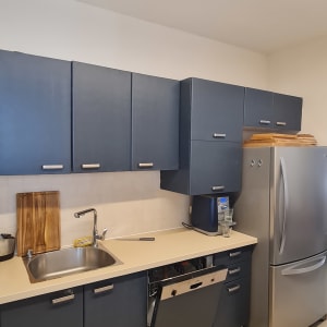 מטבח עם ארונות כהים, כיור ומקרר כסוף