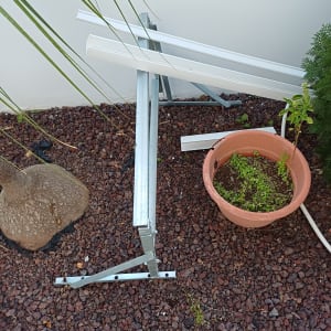 חלקי מתכת על הקרקע ליד קיר לבן