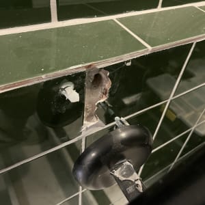 תמונה של קיר אריחים עם חור ותיקון חלקי