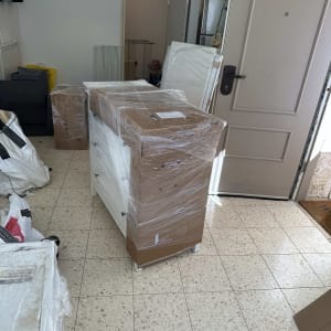 רהיטים עטופים בניילון מוכנים להובלה בדירה