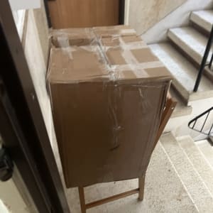 קופסה גדולה על כיסא במסדרון ליד מדרגות