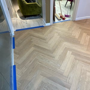 רצפת פרקט בעיצוב פישבון עם סרטי סימון כחולים