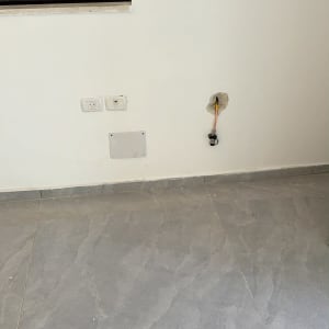 קיר עם חיבורי גז ומטבח ברקע