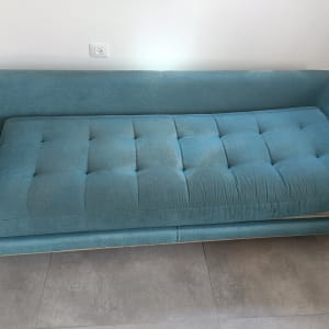 ספה כחולה על רצפת אריחים אפורה