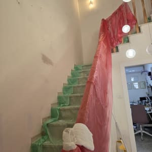 מדרגות מכוסות בניילון ירוק ואדום לשיפוץ