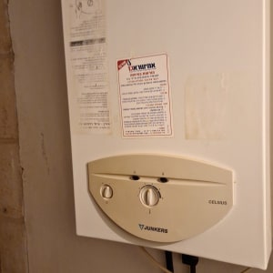 דוד חימום גז עם כפתורי שליטה ותוויות אזהרה