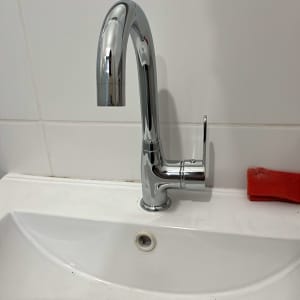 ברז כרום מותקן על כיור לבן עם ניקוז