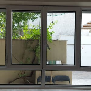 חלון אלומיניום עם נוף חיצוני של עצים