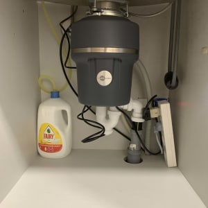 מתקן טוחן אשפה מתחת לכיור עם צינורות וחיבורים