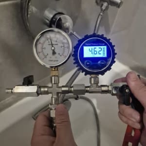 מד לחץ דיגיטלי ומד לחץ מכני בבדיקה של נזילות מים