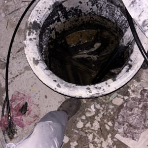 פתח ביוב עם צינורות וכלים מסביב