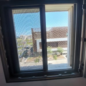 רשת נגד יונים מותקנת על חלון פתוח