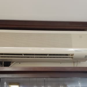 מזגן מותקן על קיר מעל ארון עץ