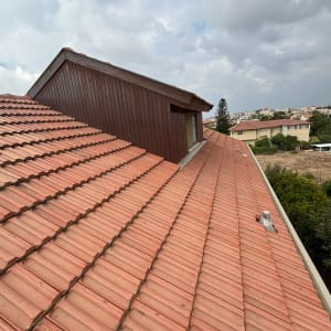 גג רעפים אדום עם מבנה עץ קטן