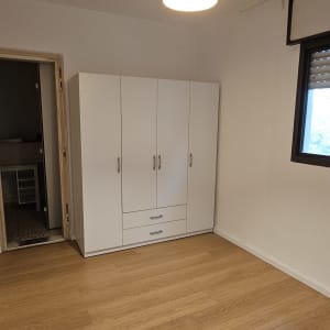 רצפת פרקט עם ארון ולמפה תלויה