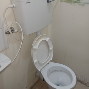 אסלה עם מיכל הדחה וצינור מים מחובר