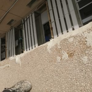 קיר עם טיח לבן, רגל עם נעל מלוכלכת