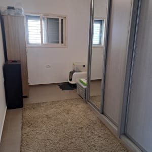 חדר עם ארון מראה, שטיח וארגז אחסון