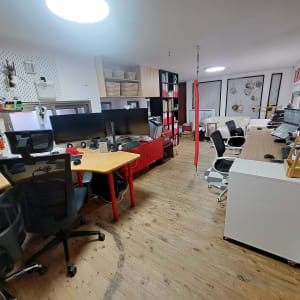 משרד עם שולחנות עבודה, כיסאות ומדפים מאורגנים