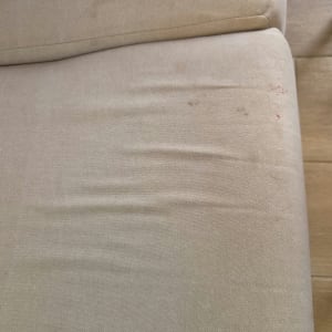 תקריב של ספת בד בהירה עם כתמים לפני ניקוי