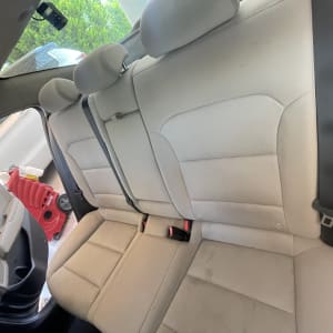 מושב אחורי של רכב עם כתמים, מכונת ניקוי אדומה